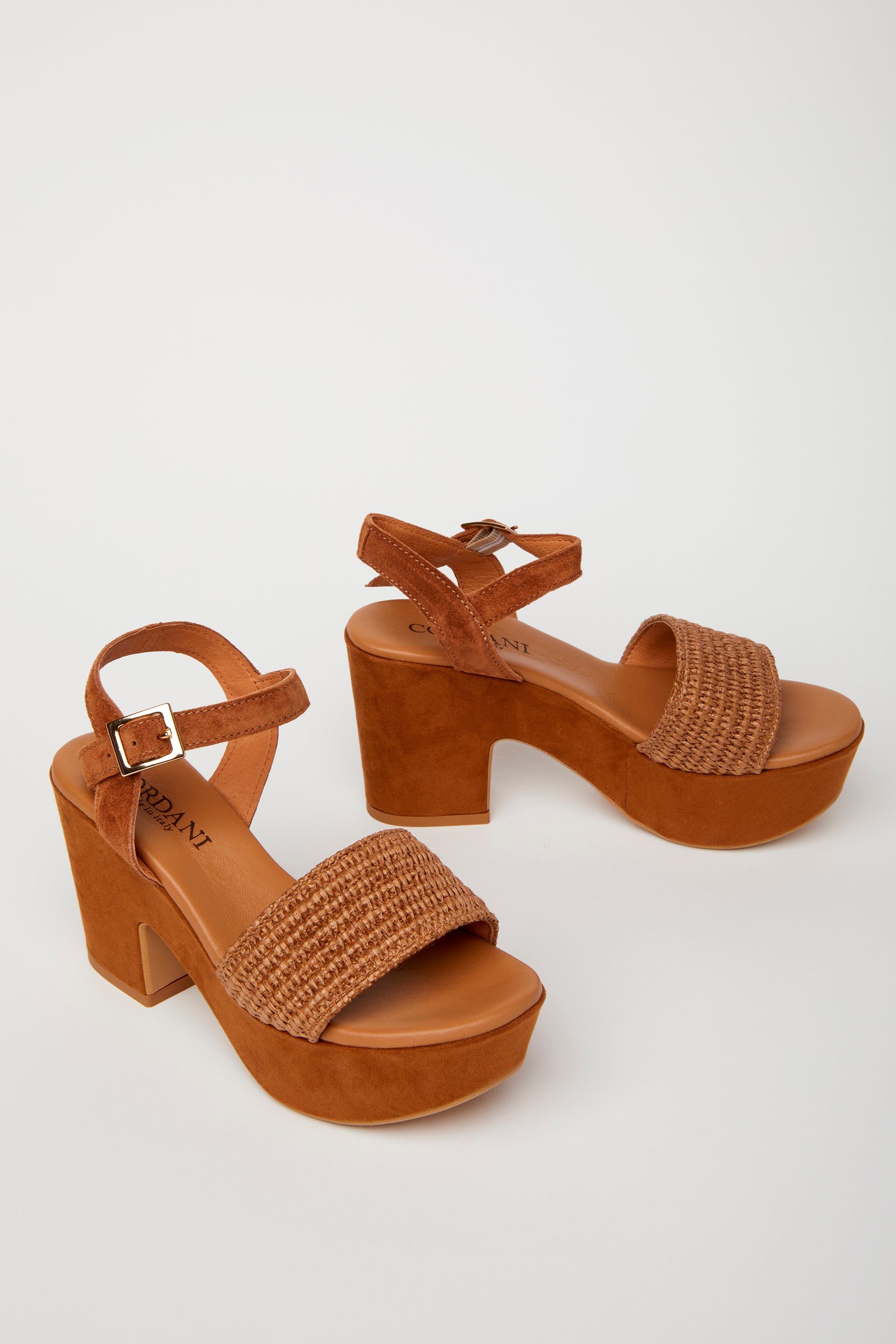 pair of brown platform sandals with a woven fabric and suede upper, featuring a suede wrapped heel and an adjustable metal buckle.