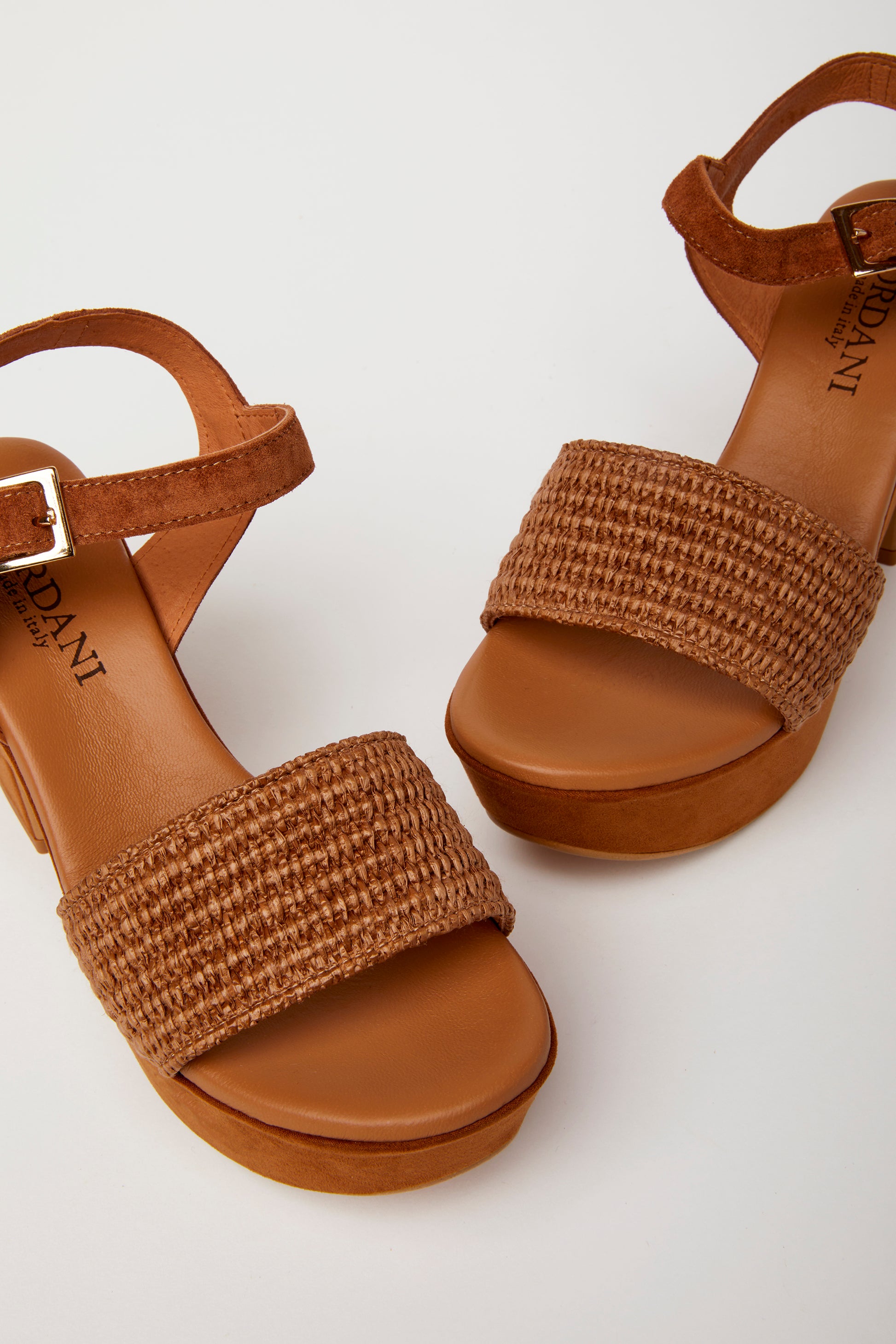 pair of brown platform sandals with a woven fabric and suede upper, featuring a suede wrapped heel and an adjustable metal buckle. detail
