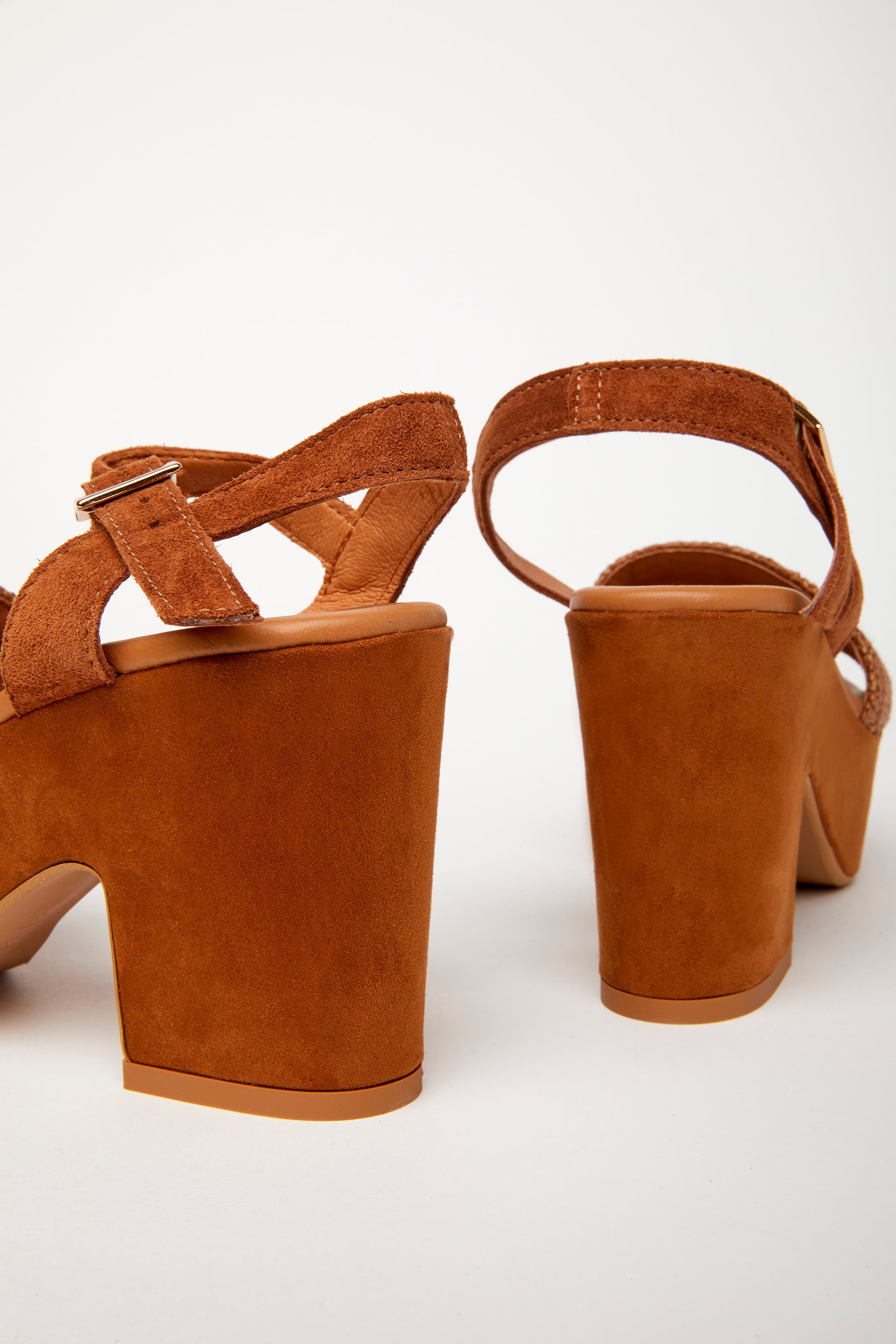 pair of brown platform sandals with a woven fabric and suede upper, featuring a suede wrapped heel and an adjustable metal buckle. detail
