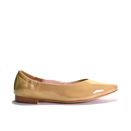 Beige patent flat shoe on a white background