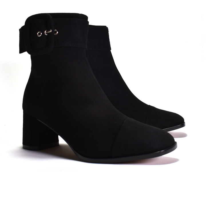 A pair of black ankle boots with a block heel, a side strap detail, and a wrapped buckle, shown on a white background.