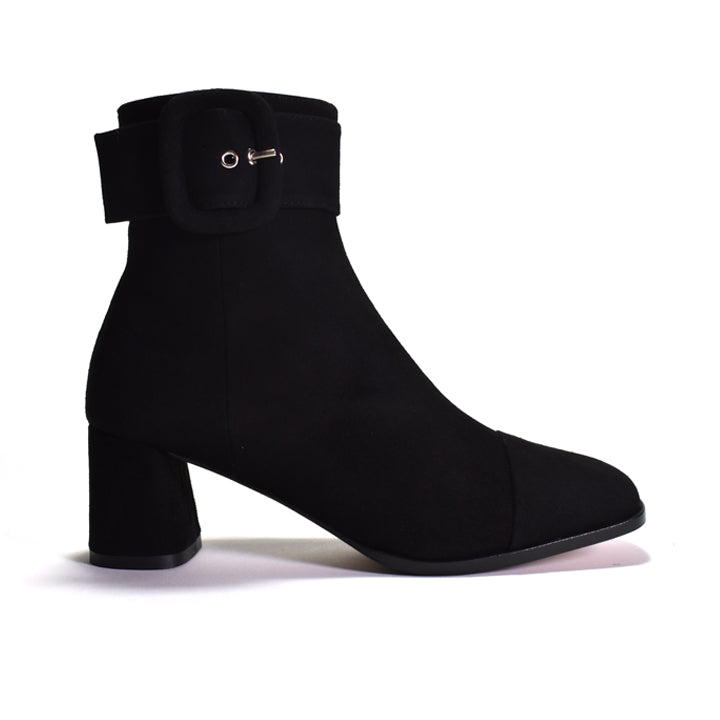A black ankle boot with a block heel and a wide strap detail with buckle, shown against a plain white background.