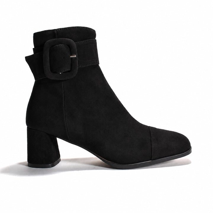 Black suede ankle boot with chunky buckle on a white background