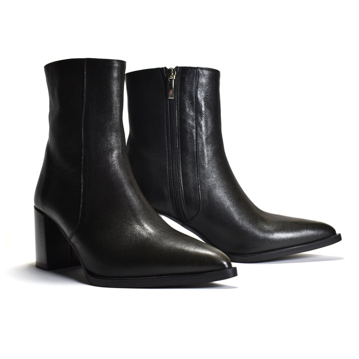 A pair of black leather ankle boots with a pointed toe and a block heel, shown on a clean white background. One boot is positioned in front showing the side profile, and the other is behind showing the inner side with a zipper.