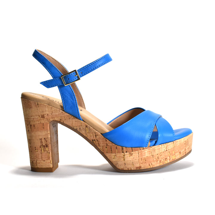 A single women's platform sandal with a bright blue leather upper and ankle strap, featuring a chunky cork-textured platform heel and a small gold buckle, shown against a plain white background.