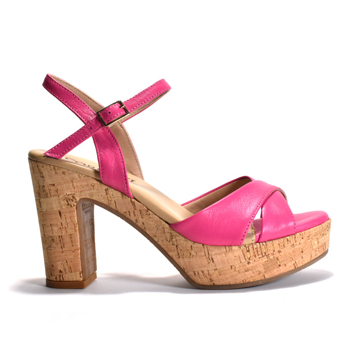 A single women's platform sandal with a bright pink leather upper and a natural cork block heel and platform, shown from a side profile on a white background.