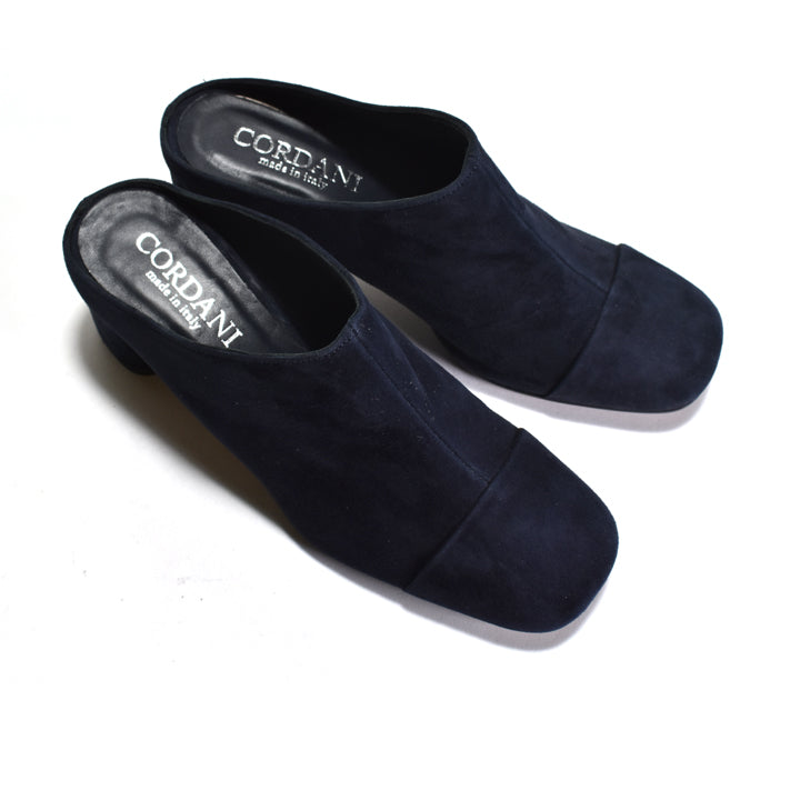 Pair of navy blue suede mules with 'Cordani' branding on a white background