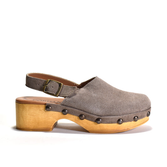 A single taupe-brown suede clog shoe with a light natural wood platform heel and dark metal studs, shown from a side profile on a white background.