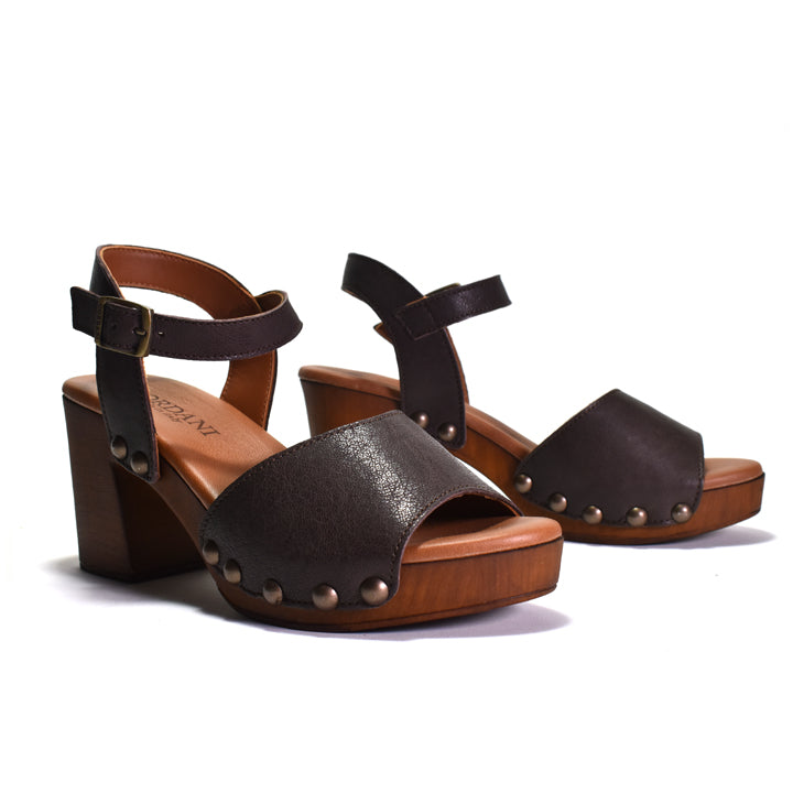 A pair of dark brown leather platform block-heel sandals with studded details on the toe straps and ankle straps, shown on a white background.