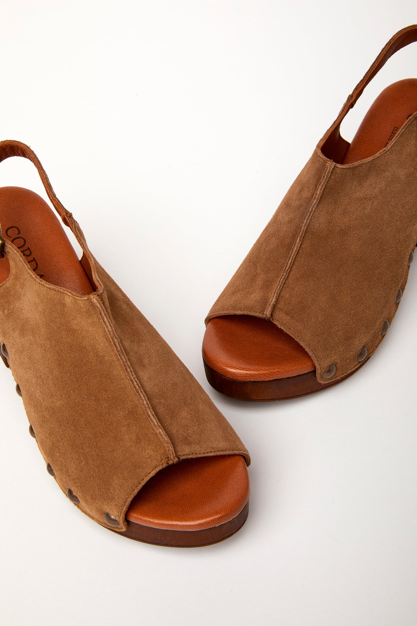 A brown peep-toe slingback heel with stud detail on a wood-like platform, with an adjustable buckle. detail