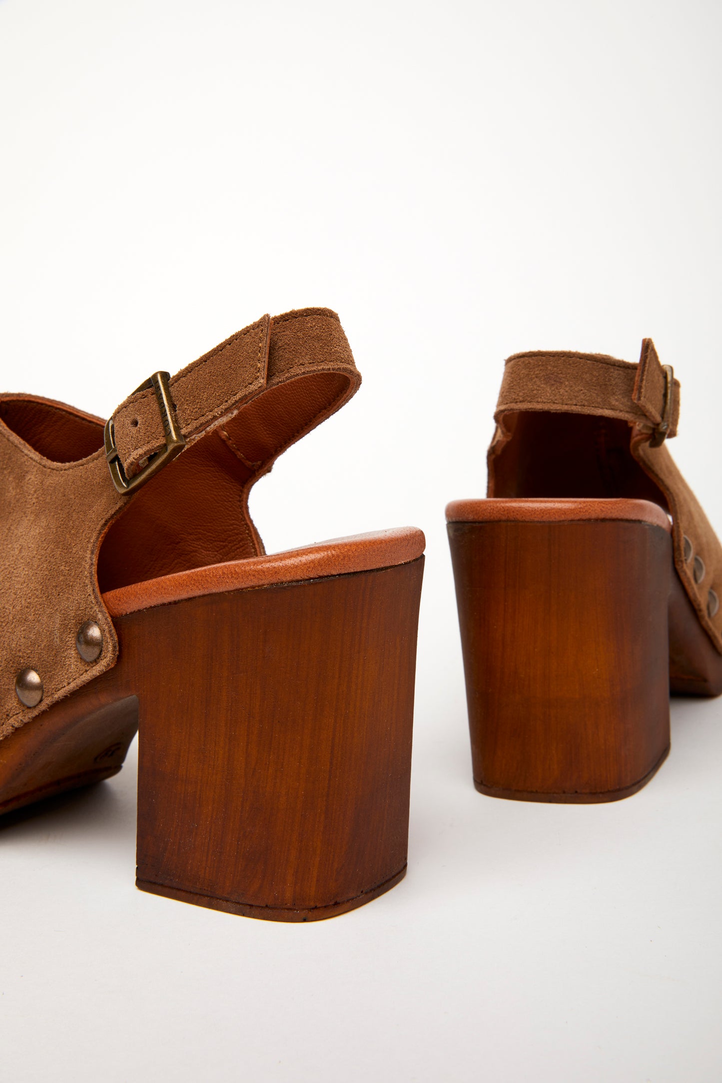 A brown peep-toe slingback heel with stud detail on a wood-like platform, with an adjustable buckle. Detail