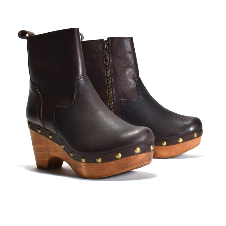 A pair of dark brown leather ankle boots with wooden platform heels, gold-tone studs, and side zippers, shown on a white background.