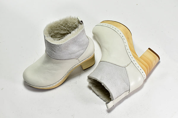 pair of white ankle bootie with a faux fur lining, suede upper, a light-weight wooden heel