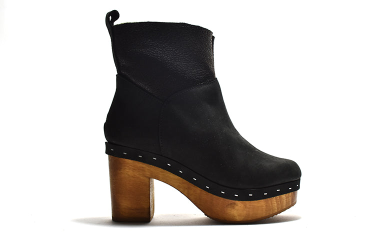 A black ankle bootie with a faux fur lining, suede upper, a light-weight wooden heel
